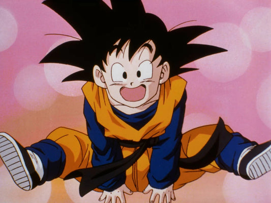 Goten enfant, en dogi orange à manches bleues et ceinture noire, bondit vers l'avant, bouche grande ouverte, sur un fond rose parsemé de halos.